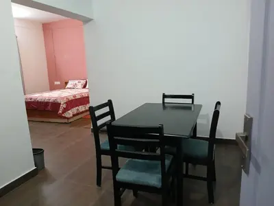 a dining room with a table and chairs and a bedroom at Willow Nest Cottages in Vattavada