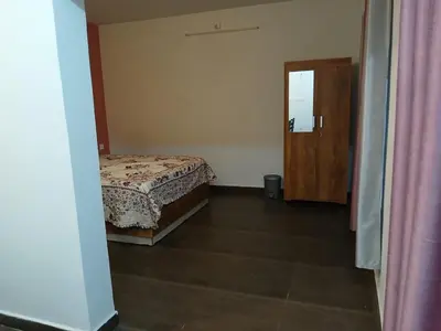 a bedroom with a bed and a wooden door at Willow Nest Cottages in Vattavada
