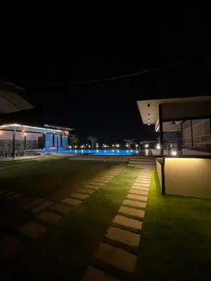 a night view of a building with blue lights at Aquatica Farms in Kodungallūr