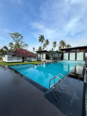 a large swimming pool in front of a building at Aquatica Farms in Kodungallūr
