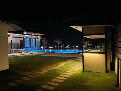 a night view of a house with a swimming pool at Aquatica Farms in Kodungallūr