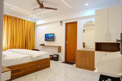 a bedroom with a bed and a mirror and a tv at 1 Bhk Luxury Flat in Samudhra Apartments -208 in Guruvāyūr