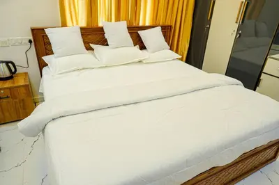 a large white bed with white sheets and pillows at Luxury room in Guruvayur Samudhra Apartments in Guruvāyūr