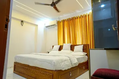 a bedroom with a bed with white sheets and yellow curtains at Luxury room in Guruvayur Samudhra Apartments in Guruvāyūr