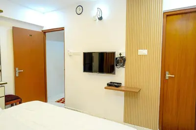 a bedroom with a mirror and a tv on a wall at Luxury room in Guruvayur Samudhra Apartments in Guruvāyūr