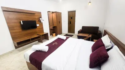 a hotel room with a bed and a television at White Oasis Residence Vythiri 3 star in Padinjarathara