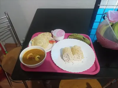 a pink tray with a plate of food and a cup of coffee at Kghomestay in Pallipuram