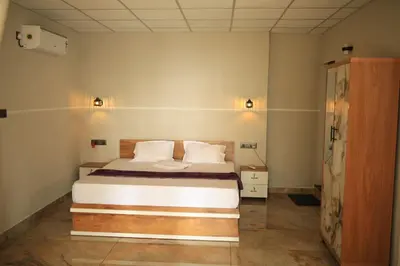 a bedroom with a bed with white sheets and pillows at Kghomestay in Pallipuram