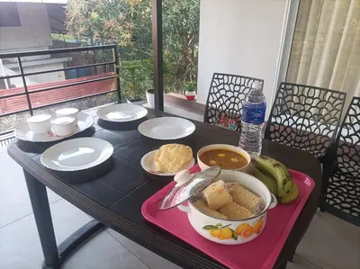 a table with plates and bowls of food on it at Kghomestay in Pallipuram