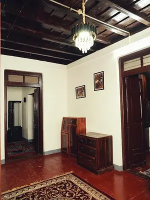 a living room with a chandelier and a table and a mirror at Cinnamon Trails plantation bungalow in Kalpetta