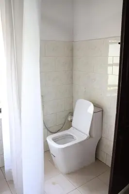 a bathroom with a white toilet in a room at Cinnamon Trails plantation bungalow in Kalpetta