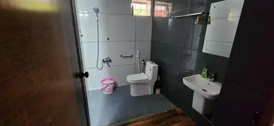 a bathroom with a toilet and a sink at Karmalhills Homestay in Tindummal