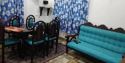 a blue couch and chairs in a room with a table at Skyfall Villa in Chillithodu