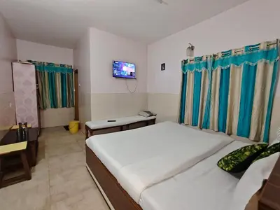 a bedroom with a bed and a tv on the wall at Pillars residency in Ooty