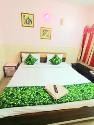 a bedroom with a bed with a remote control on it at Pillars residency in Ooty