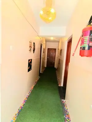 a hallway with a green carpet in a room at Pillars residency in Ooty