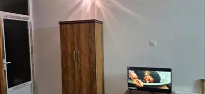 a wooden cabinet next to a wall with a tv at Stay41 in Vālpārai