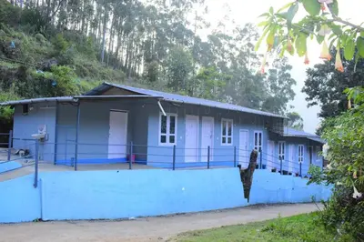 a small blue house with a blue wall at Brigmonsiya in Vattavada