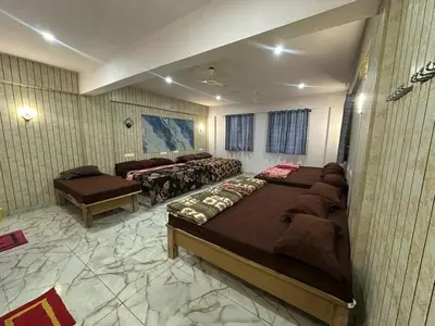 a bedroom with two beds and a couch and a table at The Royal Palace & KGN Rooms & Restaurants in Belagula
