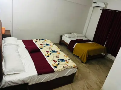 a room with two beds in a room at The Royal Palace & KGN Rooms & Restaurants in Belagula