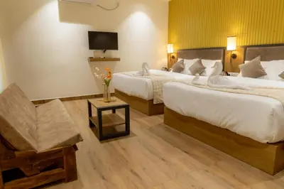 a hotel room with two beds and a tv at Coorg Kavery Estate by Aarika Resorts in Napoklu