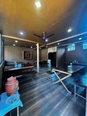 a dining room with wooden tables and a ceiling at Marayoor Mud Castle in Marayoor