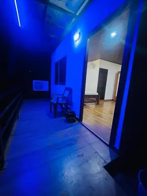 a dark room with a blue light and a chair at River bendHome in Viripara