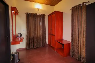 a room with a wooden cabinet and a window at Rippon Mount Resorts in Meppādi