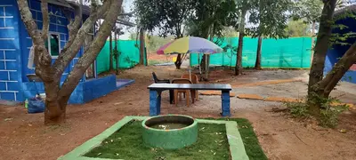 a table and chair with an umbrella in a yard at Home stay in Mysore