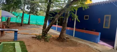 a blue building with a tree in front of it at Home stay in Mysore