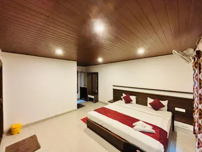 a bedroom with a large bed with a wooden ceiling at Phalam Homestay in Kushālnagar