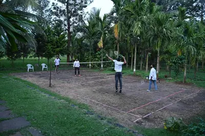 a group of people playing volleyball on a net at Phalam Homestay in Kushālnagar