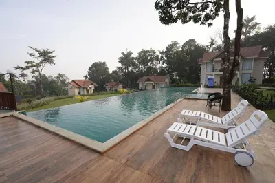a swimming pool with two white lounge chairs next to it at Mountain Vista Resorts LLP