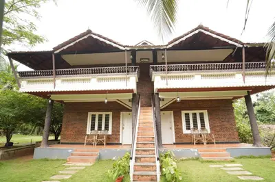 a house with a staircase leading up to it at Mango Village Resort in Kollengode