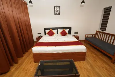 a bedroom with a bed and a bench in it at Mango Village Resort in Kollengode