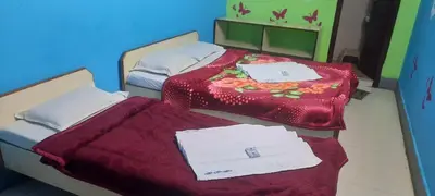 two beds in a room with towels on them at Friends Residency Mysuru in Mysore