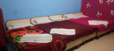 two beds in a room with towels on them at Friends Residency Mysuru in Mysore
