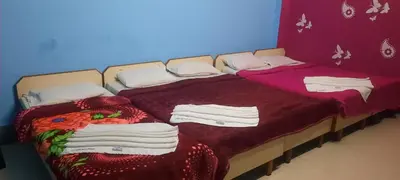 a bedroom with two beds with towels on them at Friends Residency Mysuru in Mysore