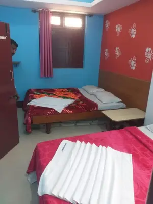 a small room with two beds and a window at Friends Residency Mysuru in Mysore