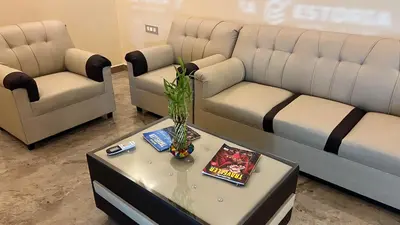 a living room with two couches and a table at Estoria Hotel and Resort in Mysore