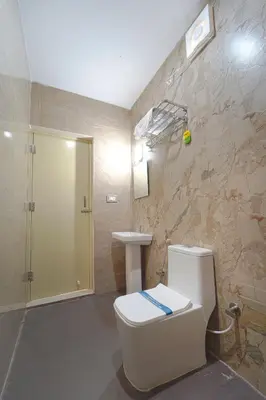 a bathroom with a toilet and a sink at Estoria Hotel and Resort in Mysore