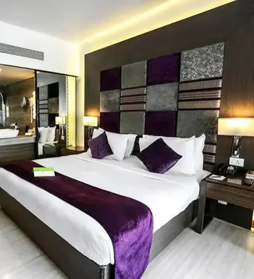 a bedroom with a large bed with purple pillows at Star Homestay in Vālpārai