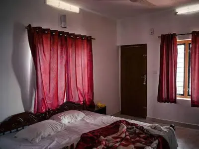 a bedroom with a bed with a red curtain at Star Homestay in Vālpārai