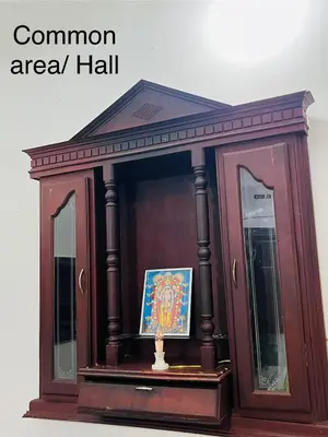 a wooden cabinet with a mirror and a picture in it at Vrindhavan stay and rooms in Guruvāyūr