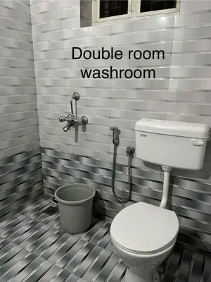 a bathroom with a toilet and a bucket at Vrindhavan stay and rooms in Guruvāyūr