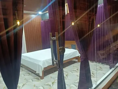 a bed in a room with purple curtains at Golden Valley Abode in Siddapur
