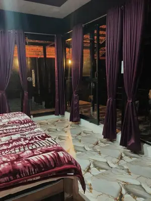 a bedroom with a large marble floor with purple curtains at Golden Valley Abode in Siddapur