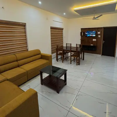 a living room with a couch and a table at KM Villa in Kottakkal