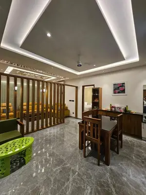 a living room with a table and chairs in a room at Kurunchi Malar Resorts in Hosūr