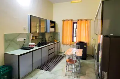 a kitchen with stainless steel cabinets and a table in it at The Cove, ' the silent Symphony ' in Parassinikadavu